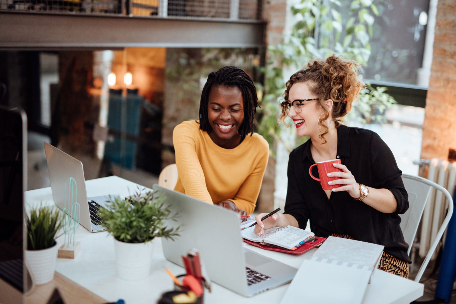 Two small business owners reviewing their finances together on a laptop