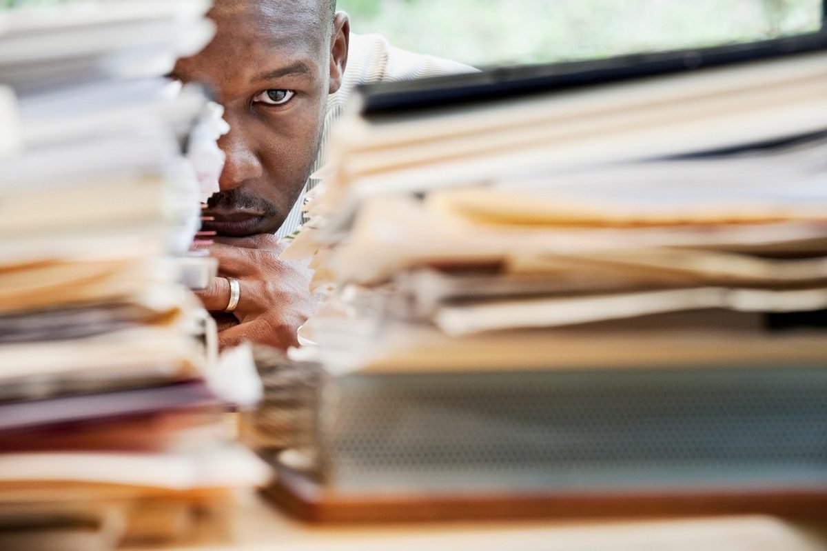 Business owner buried behind stacks of unfiled paperwork